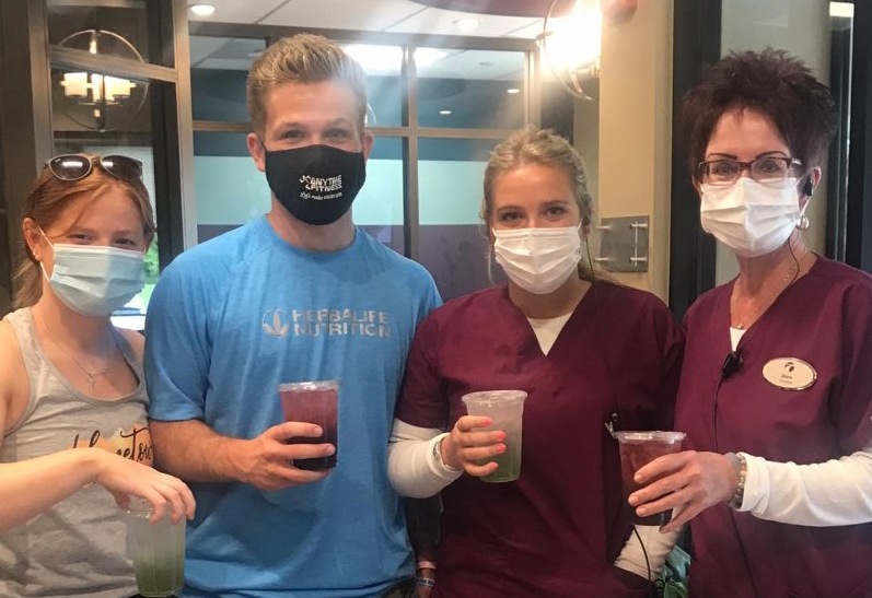 Dental team members wearing face masks and holding coffee cups