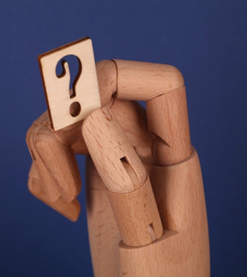 Wooden hand holding question mark