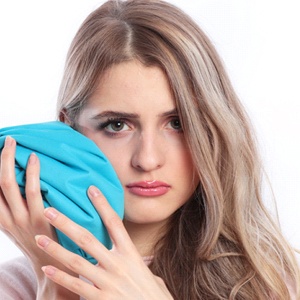 woman using ice pack on jaw