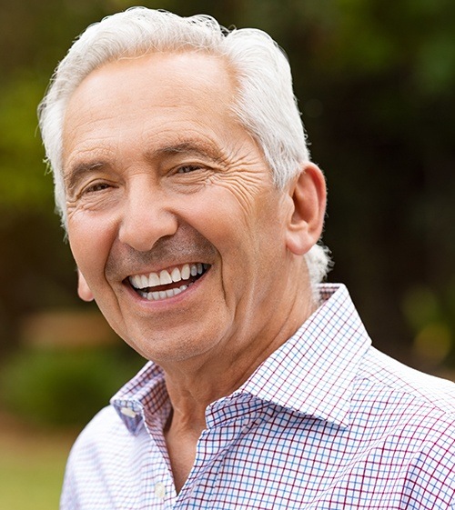 Man with dentures sharing flawless smile